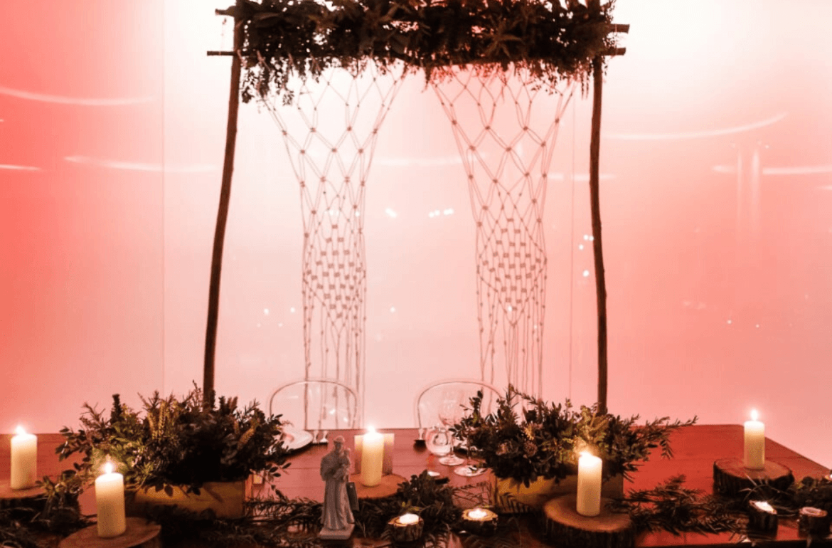 Mesa de noivos, bem decorada, com velas e um Santo António.